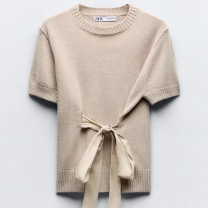 Beige knyt topp från Zara - SE BILDER NOGGRANT❣️Superfin beige stickad topp från Zara med korta ärmar och bred ribbad kant. Snygg detalj med knytband i midjan som ger en unik look. Perfekt till jeans eller kjol för en chill men ändå stilsäker vibe.