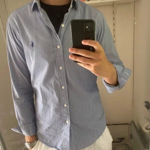 Randig blå skjorta från Polo Ralph Lauren - Snygg blå- och vitrandig skjorta från Polo Ralph Lauren, modell Regent Custom Fit. Nypris: 1600kr. Pris kan diskuteras 😉