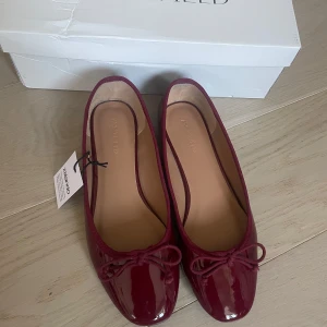 Vinröda ballerinaskor från Anna Field - Snygga ballerinaskor i vinrött lack från Anna Field. Helt nya med prislapp på köpta på zalando, säljer då jag gick ner en storlek (har storlek 39 i skor) eftersom recensionerna sa att dem var stora i storleken, tyvärr var dem för små. Skulle säga att dem är normala i storleken nu i efterhand. Kontakta mig gärna om du har några frågor! Kan mötas upp i gbg 💗🫶