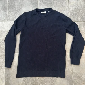 Mörkblå Sweatshirt  - Säljer en stilren mörkblå stickad tröja från LINDBERG  Tröjan har rund halsringning, ribbade muddar och lång ärm. Hör av dig vid minsta fundering MVH LUNDGRENS