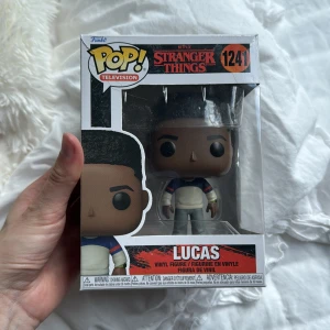 Stranger Things: Lucas (Funko Pop! #1241) - Cool Funko Pop! vinylfigur av Lucas från Netflix-serien Stranger Things. Perfekt för fans som vill samla på sina favoritkaraktärer och ge rummet en unik touch. Snygg design och en grym present till alla som älskar popkultur och retrovibbar.