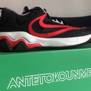 Nike Giannis Immortality 3 svart/röd - Snygga Nike Giannis Immortality 3 sneakers i svart mesh och syntet med röda detaljer och vit sula. Skorna har vågig sula, stor röd swoosh och snörning. Perfekta för dig som gillar basketinspirerad stil och vill sticka ut med cool design. Pris kan diskuteras😁😁Hör av innan köp😊