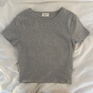 Grå croppad t-shirt från Gina💞💞 -  Jätteskön grå t-shirt från Gina Tricot! Består att den är i storlek L men skulle definitivt säga att den passar mer som S / XS. Är i jättebra skick och har inte använts så mycket💕💕
