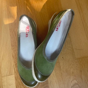 Gröna ballerinaskor Humana - Snygga ballerinaskor i olivgrönt från butiken Humana, märket Green Comfort. Ovandel i mocka och skinn med vit, lätt platåsula. Rund tå och diskreta sömdetaljer ger en clean look. Perfekta för dig som vill ha både stil och komfort.