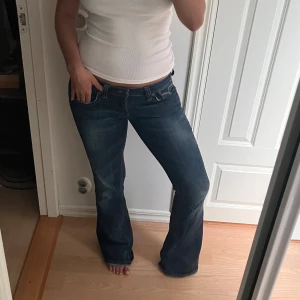 Lågmidjade bootcut jeans  - Snygga vintage jeans i bootcut-modell med låg midja. Jeansen har klassiska fickor med dekorativa sömmar och är i mjukt denimtyg. 