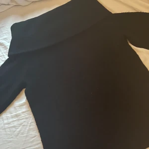 Svart offshoulder stickad tröja H&M - Svart stickad tröja från H&M i storlek S med bred offshoulder-krage. Mjuk och skön, perfekt för kyliga dagar. Långärmad modell som ger en snygg och avslappnad look. Passar dig som gillar stilrena och enkla plagg. Helt slut på H&M. Jättesnygg och praktiskt. Går att ha på sig med allt! Den är såå bekväm!! Tveka inte över att höra av dig vid frågor:)