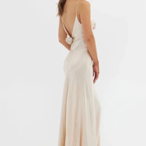 Satinklänning med låg rygg Champagnefärgad - Passar perfekt till bal, fest, bröllop osv. Sytt in så det passar en XS/S, man ser alltså inte att det är sytt. Klänningen har även sytts upp för att passa 160 cm med klack. Använd 1 gång på bal. Kan förekomma defekt nere vi klänningen. Skickar bilder på klänningen privat. Slutsåld. Inköpt för 3 100kr + tull. Pris kan sänkas!