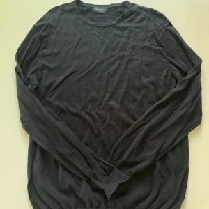 Svart långärmad tröja från Bruun & Stengade XXL - En stilren svart långärmad tröja från Bruun & Stengade i storlek XXL. Tröjan har en klassisk rund halsringning och är gjord i mjuk bomull, perfekt för en clean och enkel look. Passar dig som gillar basic och tidlös stil.