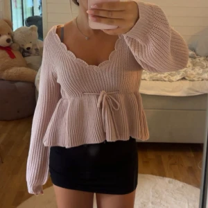 Ljusrosa stickad tröja - Supersöt ljusrosa stickad tröja från Shein med volangkantad v-ringning och knyt i midjan. Går inte att köpa länge. Storlek M.💞