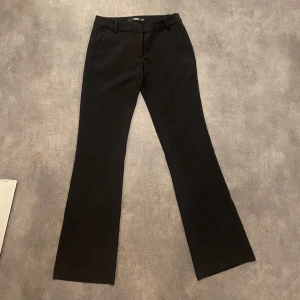 Svarta bootcut kostymbyxor BikBok - Svarta kostymbyxor från BikBok i storlek 34. Byxorna har låg midja, bootcut-ben och klassisk passform med fickor fram. har endast använt de 4 eller 5 gånger sen ja köpte de!!  