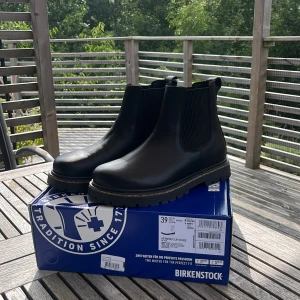 Svarta Birkenstock Chelsea boots - Säljer ett par nya svarta Birkenstock Highwood Slip On Mid boots i storlek 39. Boots med elastiska paneler på sidorna, grov gummisula och ovandel i naturläder. Snygg och stilren design som funkar till många outfits. Smal passform och klassisk rund tå. Pris kan diskuteras.