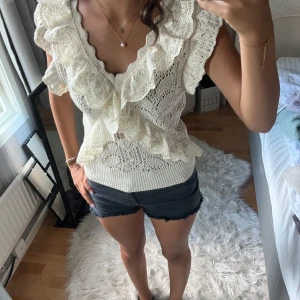 Vit spetsblus med volanger från ZARA - Säljer en superfin vit blus från zara i storlek M. Blusen har breda volanger längs v-ringningen och är gjord i stickad spets med snygga detaljer.💕