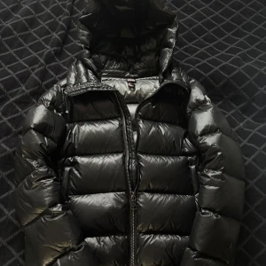 Svart Colmar pufferjacka med huva - Säljer min svarta Colmar jacka. Inga defekter och varsamt använd. Nypris 5500kr, säljes för 3000kr. Stl 42 men passar en XS eller S. (Se sista bilden för att se hur den sitter på mig. 