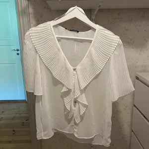 Vit volang blus från ZARA - Otroligt fin volangblus från zara. Helt oanvänd och i nyskick! Storlek xs men iom att den är luftig så skulle jag säga de passar även s/m