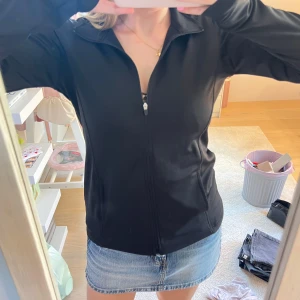 Svart vindjacka  - Svart vindjacka från LEG3ND i storlek S. Jackan har hel dragkedja framtill, två sidofickor och en enkel, sportig design med krage. Materialet är mjukt och lätt, perfekt för chill dagar eller när du är på språng.