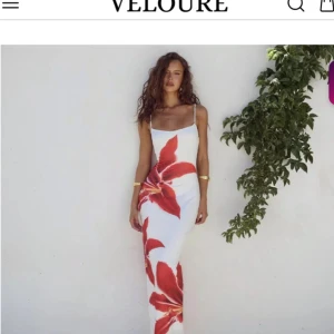 Vit långklänning med röd blomma - Säljer denna otroliga klänningen!! Aldrig använd då jag tyvärr ej hittat tillfälle till, köptes för 3-4 v sedan, köptes för 600