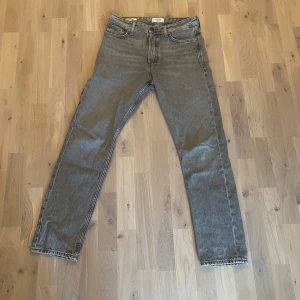 Grå loose fit jeans från Jack & Jones - Säljer ett par grå jeans från Jack & Jones i loose fit-modell, Chris. Storlek 29W och 32L. Byxorna har raka ben, klassisk femficksdesign och knäppning med knappar. Materialet är slitstarkt denim och färgen är en snygg mörkgrå ton. Perfekt för dig som gillar avslappnad stil. Skriv vid minsta fundering😁