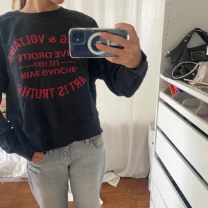 Mörk blå sweatshirt Zadig & Voltaire - Cool mörk blå sweatshirt från Zadig & Voltaire med röd tryckt text och motiv på framsidan. Tröjan har rund hals, långa ärmar och är gjord i mjuk bomull med fleece på insidan. Perfekt för dig som gillar streetstyle och vill ha något bekvämt men snyggt.