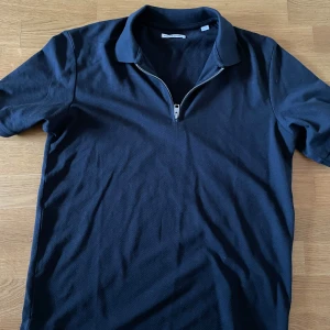 Piké Zip - Snygg marinblå pikétröja från Jack & Jones med krage och half zip framtill. Den är helt oanvänd!                      Skriv för hjälp och frågor!