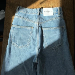 Zara the 90s Wide Leg Jeans Sky Blue - Nya jeans med prislapp kvar från Zara. Högmidjade med vida ben. Ca 86 cm innerbenslängd men är enkelt att justera då de har ev avklippt look.