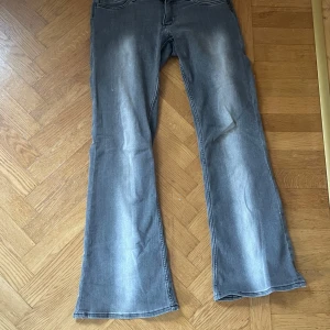 Snygga grå low bootcut jeans - Säljer dessa snygga grå jeans.Storlek 32/32 och passar mig perfekt i längden som är runt 172. De är Lågmidjade och utsvängda.De är lite slita längst ner (sista bilden) men det är inget man ser eller tänker på. Skriv för frågor eller fler bilder och kom gärna med prisförslag!!🩶🩶