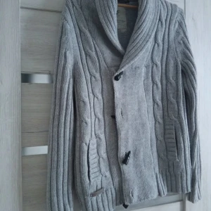 Grå stickad kofta med knappar - Säljer en grå stickad cardigan med krage perfekt nu mot höst och vinter passar nästan till allt och riktigt bra investering 