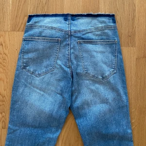 Blå bootcut jeans med rå kant - Snygga blå jeans med bootcut passform och låg midja. Jeansen har bara dragkedja och inga knappar. Du behöver inte oroa dig om att den glider ner. Dragkedjan håller bra. Perfekt för dig som gillar y2k stilen. 🌸Möts upp i Stockholm! Och endast kontanter eller Swish! 