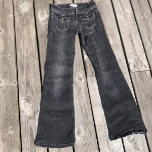 Svarta bootcut jeans från Gina Tricot - Snygga svarta jeans från Gina Tricot i bootcut-modell med coola fickdetaljer och kontrastsömmar. Jeansen har låg midja och klassisk femficksdesign, tillverkade i mjukt denimtyg som sitter skönt. Perfekta för dig som gillar retrovibbar och vill sticka ut.