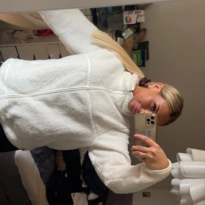 Vit teddyjacka från 157, storlek M - Mysig vit teddyjacka från 157 i storlek M. Jackan har hel dragkedja framtill, hög krage och två sidofickor. Den fluffiga fleece-texturen gör den perfekt för kyliga dagar. Passformen är normal och ärmarna är långärmade. Snygg och enkel att matcha med din vardagsstil.