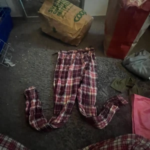 Röd-rutiga mjukisbyxor med snörning - Säljer ett par chill röd-rutiga mjukisbyxor med snörning i midjan. De har en loose passform och är perfekta för att hänga hemma eller dra på sig efter träningen. Materialet känns mjukt och skönt mot huden. Mönstret är klassiskt rutigt i rött, vitt och lite gult.