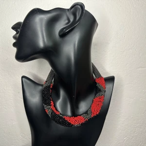 Spektakulärt retro pärlhalsband från 80/90-tal med pärlor i rött, svart & metall Vintage Statement Power-stil -  Kraftfullt vintagehalsband från 1980–1990-tal i vriden design av små glaspärlor. Färgerna rött, svart och metallgrått ger ett starkt och elegant uttryck – perfekt som statement-accessoar. Halsbandet är ca 51 cm långt och 2,7 cm brett. Mycket fint second hand-skick med bevarad glans. Jag använder det inte längre och säljer därför vidare. Jag prutar inte, men erbjuder rabatt vid köp av flera saker. Jag rensar smyckesskrin och garderob – kika gärna på mina andra annonser också!  ⸻  