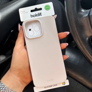 Vit silikonväska Holdit iPhone 15 Pro Max - Snyggt och stilrent vitt silikonskal från Holdit som passar iPhone 15 Pro Max. Skalet har en slät yta och skyddar mobilen mot repor och stötar. Perfekt för dig som vill ha en clean look på din mobil.