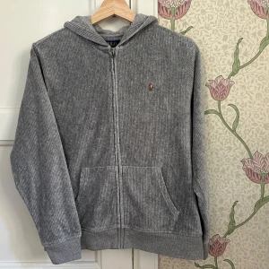 Grå exclusiv Ralph Lauren Hoddie - Ovanlig men snygg Ralph lauren hoddie, perfekt för en mer laidback look💫 Skick 9/10✅ Nypris ca 2500, vårt pris 599✅ Storlek 14-16, alternativ XS