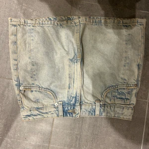 Ljusblå jeanskjol med fickor - Säljer en ljusblå jeanskjol med cool tvättad look och klassiska fickor både fram och bak. Low waist