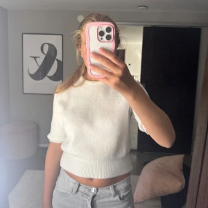 Vit croppad stickad tröja från Zara - Superfin vit stickad tröja från Zara med kort ärm och croppad passform. Rund halsringning och bred ribbad kant nedtill.❣️