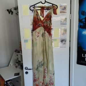 Blommig långklänning med omlott - långklänning med blommigt mönster. Har defekt, kom PM för mer information å bilder