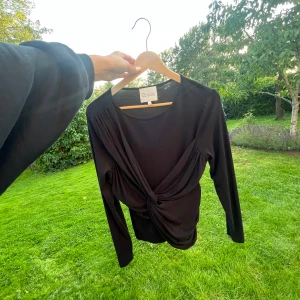 Svart omlottopp från My Essential Wardrobe - Jättefin tröja med mjukt material, aldrig använd. 💕Nypris ca 800 kr