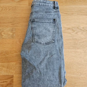 Grå loose fit jeans mid waist storlek 146 - Säljer ett par grå loose fit jeans med mid waist. Jeansen har klassisk femficksdesign, raka ben och snygg tvättad look. Perfekta för dig som gillar avslappnad stil och vill ha bekväma jeans med lite extra utrymme.