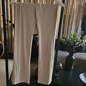 Beige ribbade mjukisbyxor - Zara - Säljer ett par beige ribbade mjukisbyxor med wide fit. Byxorna har en mjuk och stretchig känsla, perfekta för chill dagar. De är helfärgade och har en snygg, enkel look som passar till allt. Supersköna och lätta att matcha med hoodies eller t-shirts. Byxorna har även slitsar längst ned som man kan se på sista bilden.