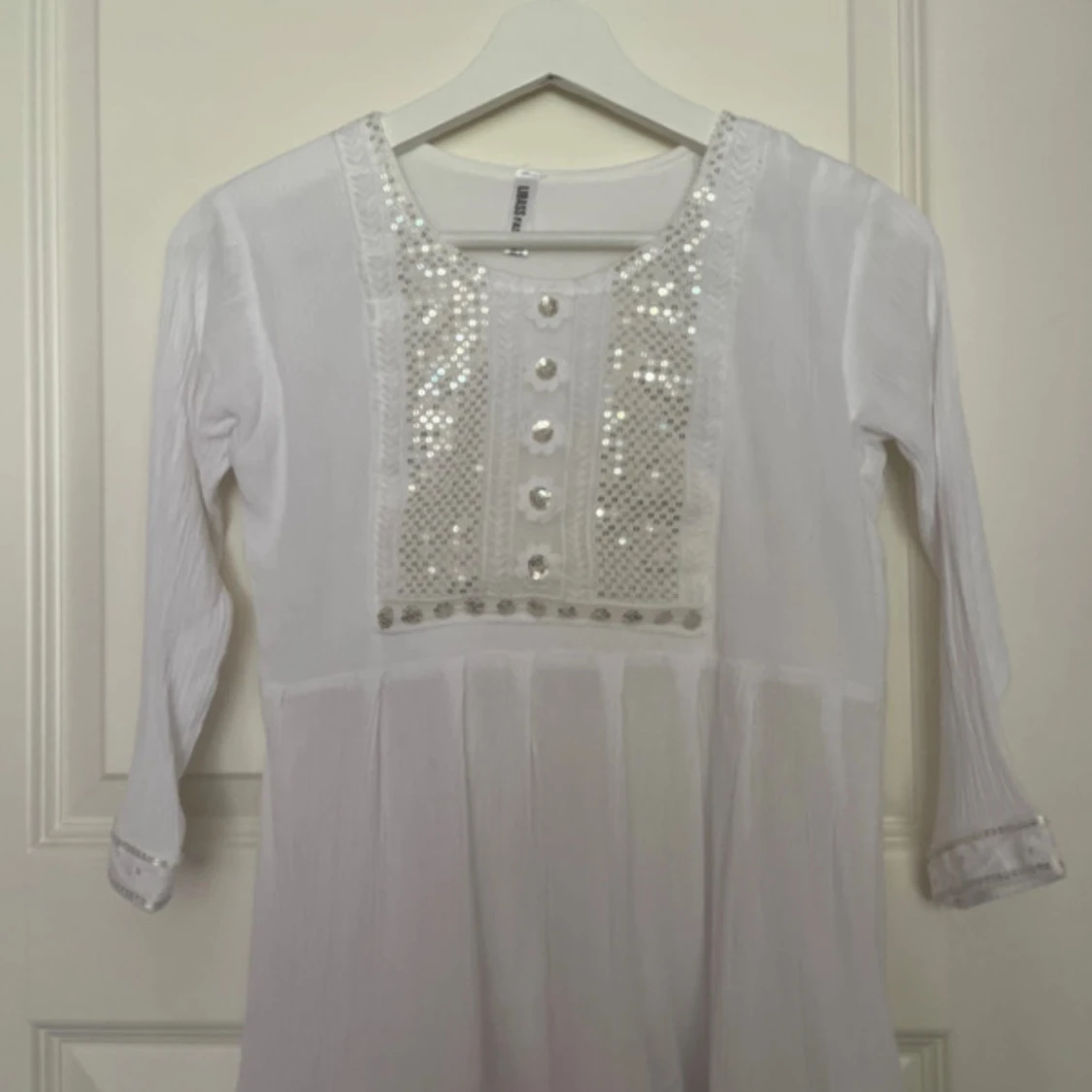 Vit top med paljetter