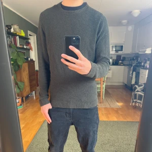 Mörkgrå stickad tröja Massimo Dutti - Säljer en mörkgrå stickad tröja från Massimo Dutti. Tröjan har rund halsringning, lång ärm och en clean, klassisk look. Perfekt för dig som gillar enkel och stilren design. Materialet är mjukt och ger en skön känsla mot huden.