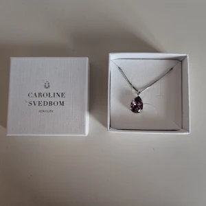 Caroline Svedbom Mini Necklace Iris Rhodium - Caroline Svedbom Mini Drop Necklace Iris Rhodium i oanvänt skick och komplett med asken.  Storlek: Droppe 14 x 10 mm, längd 50 cm, inklusive en 5 cm lång förlängningskedja Plätering: 18K Guld / Rodium Världens högsta kvalitet på kristaller  Jag säljer även matchande örhängen I en annan annons så kika gärna på den.