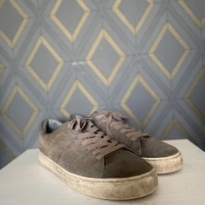  mockasneakers med platt sula - Snygga sneakers mocka med matchand snören och vit platt sula. Skorna har en klassisk rund tå och stilren design som passar till det mesta. Perfekta för dig som gillar en enkel men trendig look.