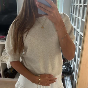 Beige stickad tröja Vero Moda - Superfin beige stickad tröja från Vero Moda med puffade axlar och ribbad rund hals. Den är lite nopprig dock!!💕💕
