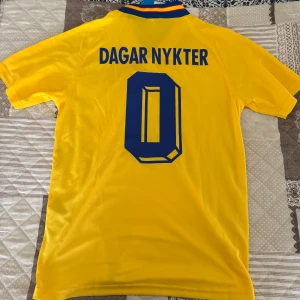 Svensk landslagströja Adidas gul/blå - Retrotröja från Svenska landslaget med roligt tryck på ryggen, perfekt för festivaler, utgångar eller bara casual användande. Helt ny med lappar kvar.