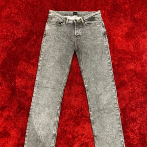 Grå vida jeans med tvättad look - Säljer ett par grå jeans från Monten med tvättad finish. Klassisk femficksmodell, snygga detaljer på bakfickorna. Perfekta för dig som gillar en clean och modern stil.