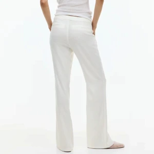 Vita linnebyxor med wide fit - Snygga vita linnebyxor med rak och vid passform. Byxorna har diskreta fickor och en clean midja utan synliga knappar eller dragkedja. Perfekta för en chill och fräsch look, särskilt under varmare dagar. Lätta och luftiga i materialet. Lågmidjade 