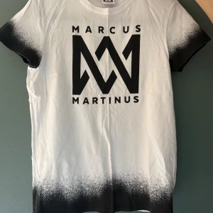 Marcus & Martinus vit t-shirt S - Äkta merch. Vit t-shirt från Marcus & Martinus med svart logotryck på bröstet och text på ryggen. Använd men i bra skick! 