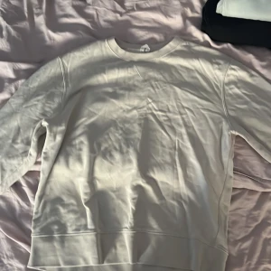 Beige sweatshirt från ARKET, storlek L - Säljer en stilren beige sweatshirt från ARKET i storlek L. Tröjan har rund hals, långa ärmar och är tillverkad i mjuk bomull. Perfekt för dig som gillar minimalistisk och clean look. Passar dig som vill ha en enkel och snygg tröja till vardags.