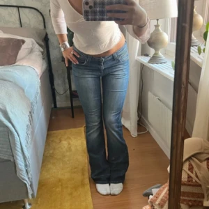 Blå bootcut jeans från Lee - Snygga blå bootcut jeans från Lee med låg midja. Midjemåttet är ungefär 37cm. Jeansen har klassisk femficksdesign, slitningar och Lee-logga på bakfickan. Skriv för fler bilder. Priset kan varieras vid snabbt köp. ❤️